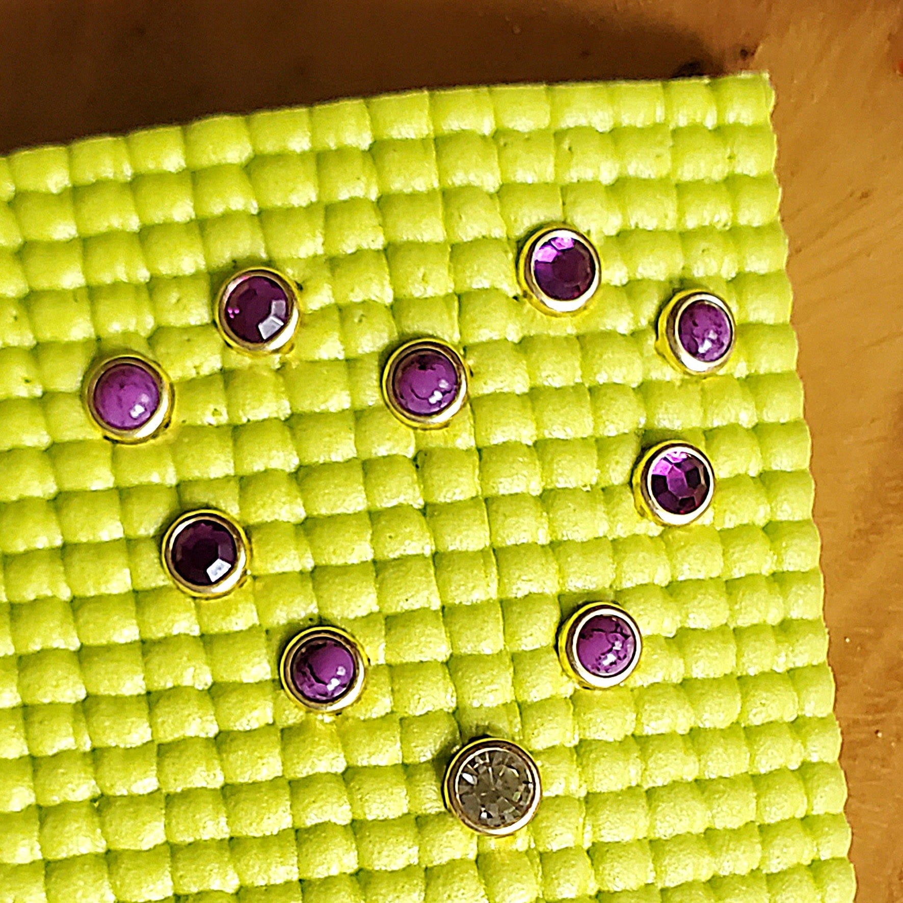 purple stones and gems installed in a yellow yoga mat in the shape of a heart