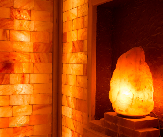 a Himilayan salt lamp glowing in a salt room for yoga