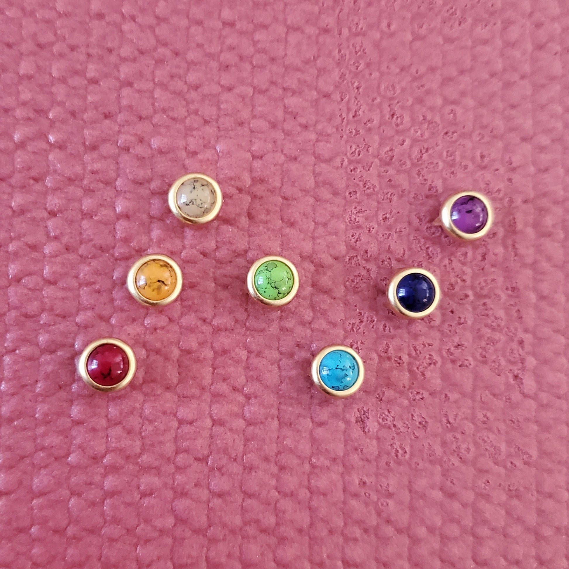 Set of colorful gemstone yoga mat charms installed in on a pink yoga mat