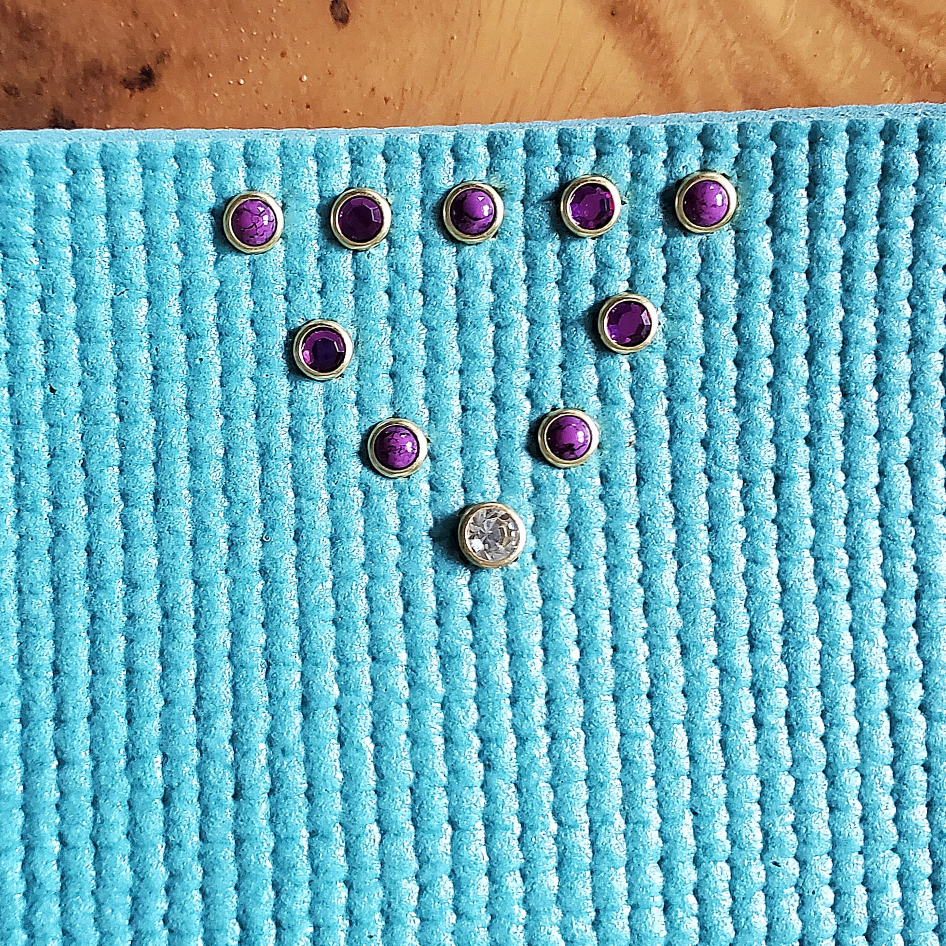 purple gems and stones installed in a blue yoga mat